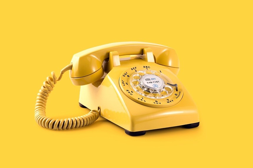 A yellow retro telephone on a yellow background